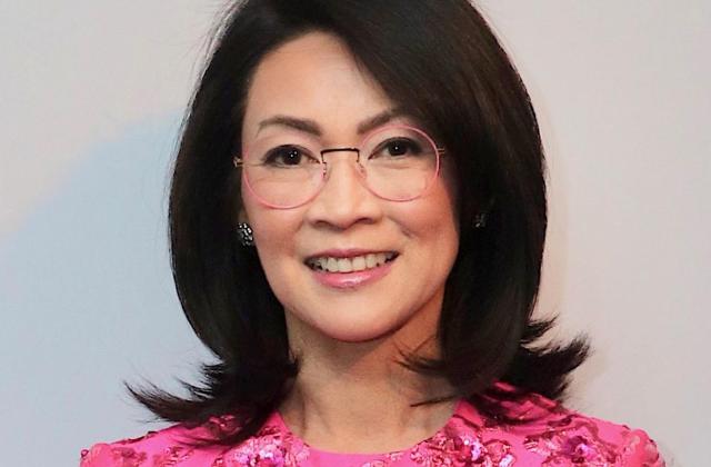 Headshot of smiling woman in a fuschia blouse.