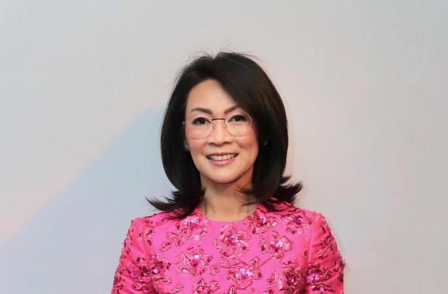 Headshot of smiling woman in a fuschia blouse.